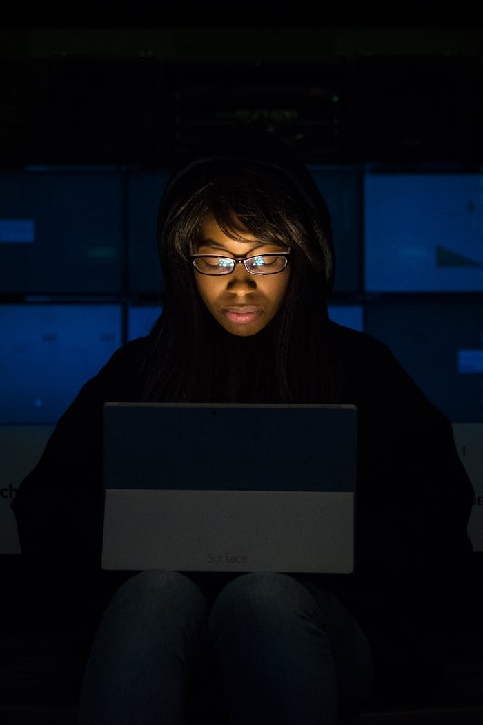Woman immersed in laptop work during nighttime. Technology and focus in action.