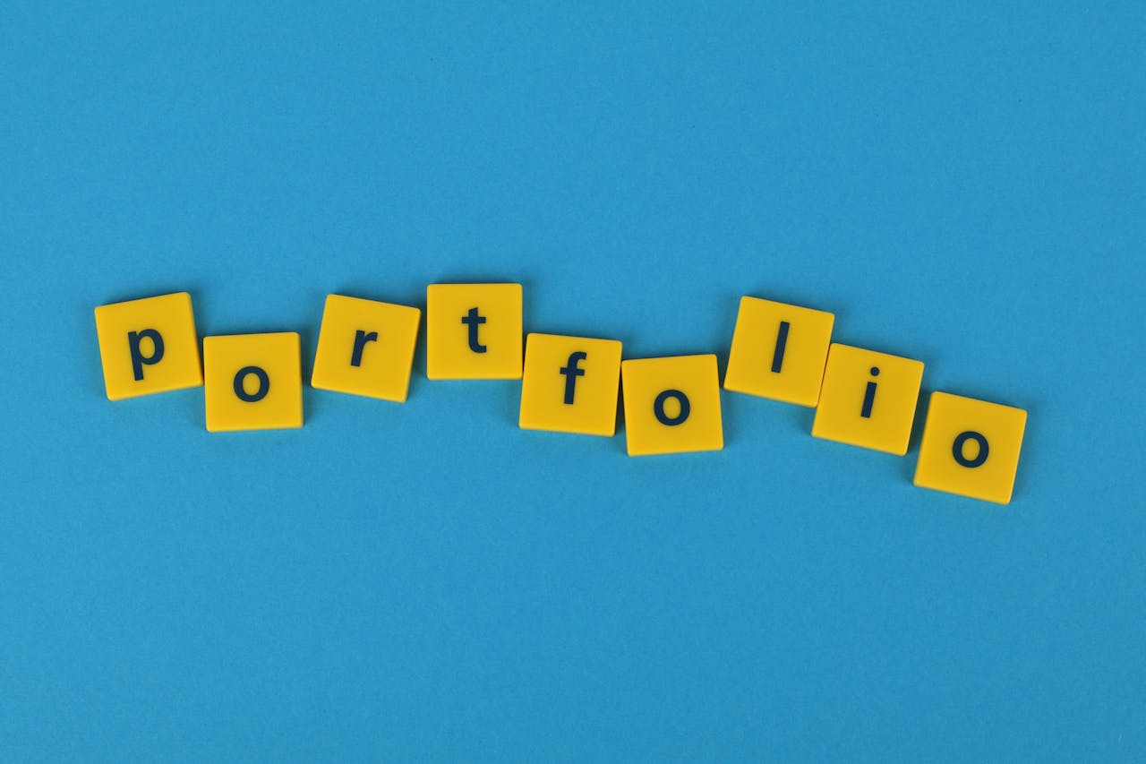Yellow Scrabble tiles on a blue background spelling 'portfolio'. Perfect for business themes.